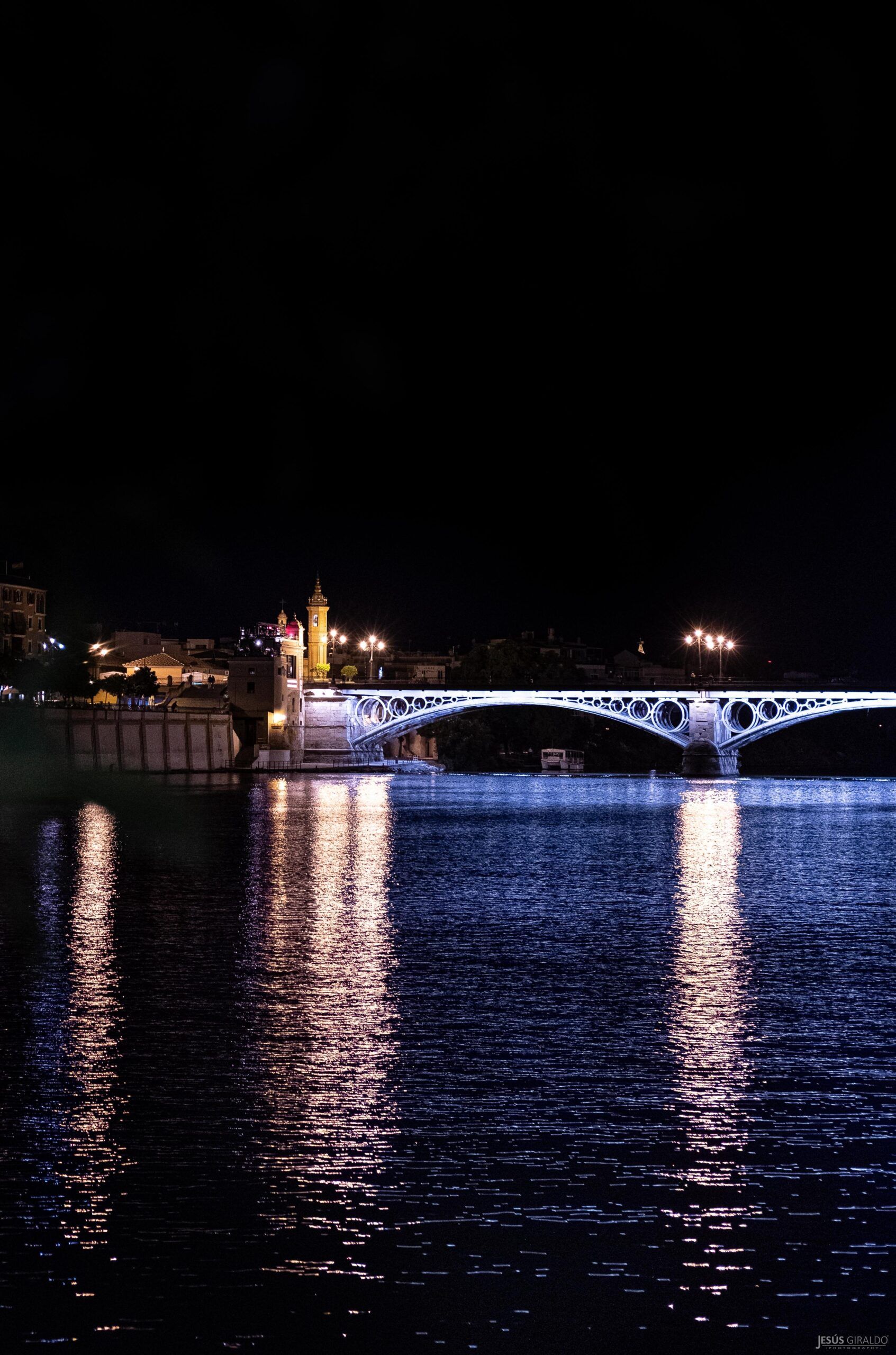 La Sevilla más azul: el Puente de Triana se convierte en una obra de arte nocturna en la mirada de Jesús Giraldo - Gastronomía y Moda
