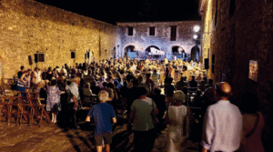 Calle de un pueblo de Huesca con muy público para ver una representación del festival del camino de santiago