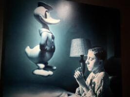 Niño rezando al Pato Donald con brazos ortopedicos, autorretrato de Helnwein. Pintura. Fotografía Cristina Gala