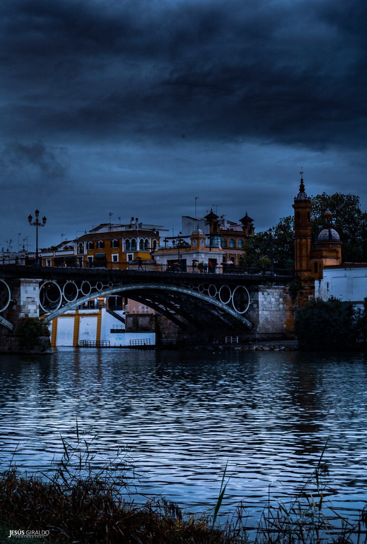 La Sevilla más azul: el Puente de Triana se convierte en una obra de arte nocturna en la mirada de Jesús Giraldo - Gastronomía y Moda
